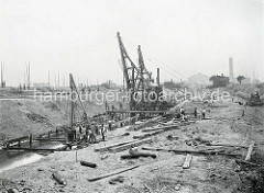 Baustelle vom Hamburger Baakenhafen - Baugerüste und Bauarbeiter; der Baakenhafen wurde als Liegeplatz für Flussschiffe geplant, dann als Seehafen ausgebaut. Im Hintergrund die Gasanstalt am Grasbrook.