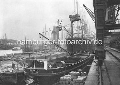 Historische Aufnahme von der Arbeit im Hamburger Hafen - Schuten, Dampfer und Getreideheber im Kaiser-Wilhelm-Hafen.