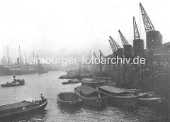 Kaiser Wilhelm Hafen / Auguste Viktoria Kai; Schuten und Kähne am Hafenkai; ein Ewerführer steuert seine Schute mit einem Peekhaken. Alte Fotografien aus dem Hafen Hamburgs.