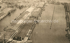 Historisches Flugbild vom Kaiser Wilhelm Hafen - Lagerschuppen am  Auguste Viktoria Kai, lks. davon der Kuhwerder Hafen und die Kaischuppen am Grevenhofer Ufer; im Hintergrund die Grevenhofer Schleuse.