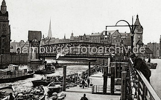 Schiffsponton am Gemüsemarkt bei den Deichtorhallen - Schuten mit ihrer Ladung haben am Anleger fest gemacht. Markthändler tragen ihre Ware in Kiepen zum Markt. Ein Schlepper zieht einen mit Kisten beladenen Kahn aus dem Oberhafen.