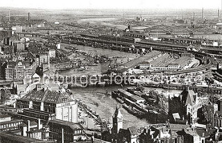 Blick über den Oberhafen und den Oberhafenkanal - im Vordergrund der Portalturm der Wandrahmsbrücke. In der Bildmitte die Oberhafenbrücke und der Güterbahnhof, dahinter die Kaischuppen am Versmannkai des Baakenhafens.