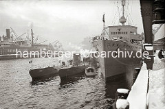 U-Boote und ein U-Boot Begleitschiff haben am Versmannkai im Hamburger Baakenhafen fest gemacht. Hoher Schnee liegt auf der Kaianlage - ein Kaiarbeiter schaufelt unter dem Portal eines Halbportalkrans die Kaifläche frei.