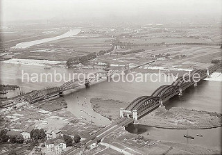 Elbbrücken bei Harburg über die Süderelbe - rechts die Eisenbahnbrücke und lks. die Strassenbrücke mit den beiden Sandsteinportalen. Lks. davon die Einfahrt zur Harburger Schleuse, die zum Harburger Hafen führt. Auf der anderen Elbseite im Hinter