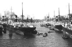 dicht gedrängt liegen die Schiffe im Hamburger Hafen - links Frachter an Duckdalben im Oderhafen; dazwischen fahren Barkassen und kleine Schlepper - rechts das Stettiner Ufer und seinen Ladekranen.