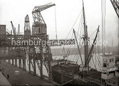 Ein Frachter liegt am Schuppen 82 des Chilekais im Oderhafen, eines der vielen Hafenbecken im Hamburger Hafen. Über einen Dreifachkran werden grosse Frachtkisten an Bord des Schiffes gebracht. Im Hintergrund die Kaischuppen am Mönckebergkai des El