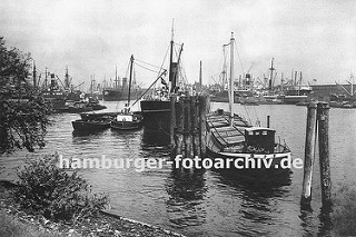 Blick vom Lübecker Ufer in den Hansahafen - im Hintergrund die Schornsteine der Frachtschiffe, die am Oswaldkai liegen und deren Ladung gelöscht wird. Im Vordergrund hölzerne Duckdalben, die aus langen Baumstämmen gefertigt werden und tief in den