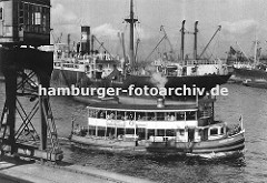 Ein Schiff der Hamburger Hafenrundfahrt fährt die Hamburg Touristen durch den Oderhafen - auf dem oberen Deck der GODEFFROY stehen die Hamburg-Besucher und beobachten das Geschehen in Hamburgs Hafen. Im Vordergrund ein fahrbarer Hafenkran am Bresl