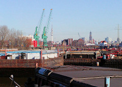 Schuten und Arbeitsschiffe im Travehafen, Hamburg Steinwerder - im Hintergrund die Ellerholzschleuse und der Kirchturm der St. Michaeliskirche und der Fernsehturm.