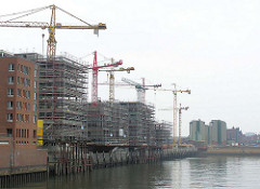 Rohbauten und Baukräne am Sandtorkai in der Hamburger Speicherstadt / Hafencity, Blick über das Hafenbecken vom Sandtorhafen zum Lagergebäude der Kaffeelagerei, dahinter der Kaispeicher B. (2004)
