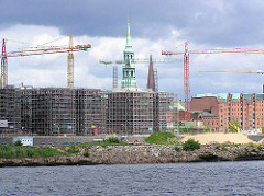 Blick über den Grasbrookhafen / Dalmannkai zum Sandtorhafen / Sandtorkai - eingerüstete Rohbauten, Baustellen der entstehenden Hafencity; Kirchtürme der St. Katharinenkirche und Jacobikirche. (2004)
