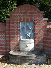 Fotos vom Gelände des Barmbeker Krankenhaus in Hamburg Barmbek Nord; Brunnen mit Metallrelief - Krankenschwester reicht einem alten Mann einen Wasserkrug.