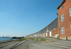 Lagergebäude am Versmannkai / Baakenhafen, Hafenbecken im Hamburger Hafen. Schienen der Hafenbahn auf dem Kai.
