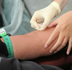 Blutspende im Blutspendedienst in Hamburg Eilbek; die Nadel für die Blutspende wird vorsichtig in die Armvene eingesteckt.