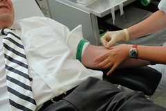 Blutspende im Blutspendedienst in Hamburg Eilbek; der Blutspender liegt entspannt auf dem Stuhl; im Hintergrund die Blutproben + Karteikarte des Spenders.