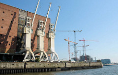 Hafenkräne am Kaispeicher A in der Hafencity Hamburgs - im Hintergrund Baukräne am Dalmannkai im Grasbrookhafen. ( 2006 )