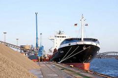 Frachtschiff im Hamburger Hafen - Schüttgut am Kirchenpauerkai; im Hintergrund die Norderelbbrücken.