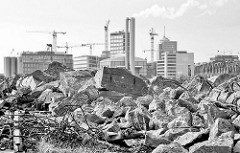 Schuttberge am Versmannkai im Baakenhafen - im Hintergrund Gebäude der Hamburger Hafencity.