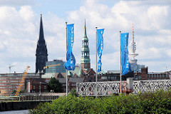Flaggen der Hafencity am Strandhöft - im Hintergrund die Baakenbrücke über den Magedburger Hafen und die Kirchtürme der St. Nikolaikirche und der St. Katharinenkirche; re. der Hamburger Fernsehturm. ( 2007 )