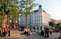 Umgebauter Spielbudenplatz - Sitzplätze auf Treppen in der Sonne - im Hintergrund die Polizeiwache und Gründerzeitarchitetkur an der Davidstrasse.