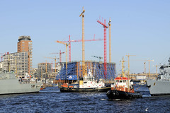Fotos vom Hamburger Hafengeburtstag - Hochbetrieb auf dem Wasser und an Land; Schlepper zwischen Kriegschiffen - im Hintergrund die Baustelle der Elbphilharmonie.
