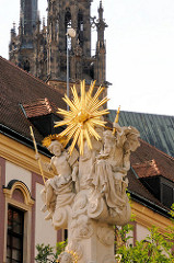 Marienfigur auf einem Sockel - im Hintergrund die Türme der Kathedale / Basilika St. Peter und Paul in Brno, Brünn.