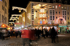 Weihnachtlich beleuchtete Strasse in Dresden - Weihnachtspyramide, Marktbesucher.