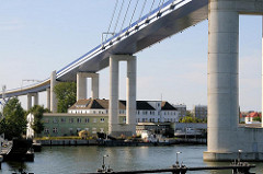 Blick auf die Rügenbrücke bei Stralsund - Y-Stützpaare; Wohnhäuser und Gewerbe unter der Brücke.