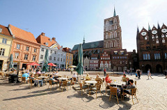 Alter Markt - norddeutsche Backsteingotik - Rathaus u. Nikolaikirche  Hansestadt Stralsund; Café mit Tischen in der Sonne auf dem Strassenpflaster.