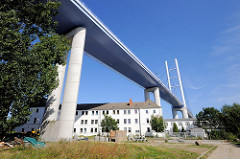 Hochbrücke Rügenbrücke bei Stralsund - mehrstöckiger Wohnblock unter dem Brückenzug.