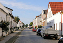 Klassizistische Wohnhäuser mit blühenden Rosensträuchern an der Strasse - Bilder aus Putbus / Rügen.