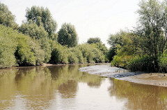 Lauf der Krückau bei niedrigem Wasser - an den Flussbiegungen entstehen Untiefen durch Ablagerungen.
