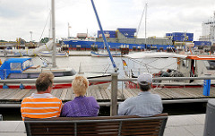 Blick über den Sportboothafen Brunsbüttel an der Schleuse - ein Containerschiff hat die Schleusenkammer verlassen und fährt in den Nord Ostsee Kanal ein.