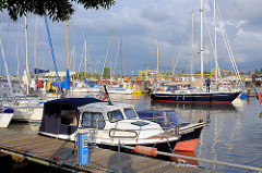 Segelboote und Motorboote liegen zum Teil nebeneinander in Päckchen.