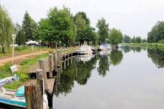 Wasserwanderrastplatz Eldekrug bei Freesenbrügge am Eldekanal. Sportboote liegen am Steg.