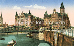 Blick auf die Wilhelminenbrücke - rechts führt eine steinerne Treppe zum Wasser. Ein Kran mit Handbetrieb steht an der Kaimauer vom Wilhelminenplatz. Am Kehrwiederfleet die Frontansichten der Speichergebäude A und J mti den neogotischen Gieb