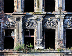 Alte Hausfassade mit Stucksäulen und Dekor - leerstehendes Wohngbäude.