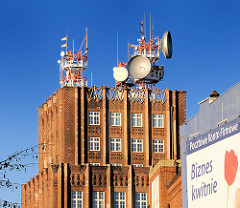 Expressionistisches Postscheckamt Breslau, Wroclaw - Ziegelgebäude, Backsteinfassade - Satellitenschüsseln und Sendeanlagen auf dem Dach.