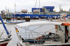 Blick über den Sportboothafen Brunsbüttel an der Schleuse - ein Containerschiff hat die Schleusenkammer verlassen und fährt in den Nord Ostsee Kanal ein.