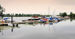 Sportboothafen an der Eider - Bootssteg mit Motorbooten und Segelschiffen - Sportboothafen Süderstapel.