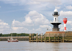 Leuchtfeuer an der Einfahrt zur Schleuse Nord-Ostsee-Kanal in Brunsbüttel - ein Sportboot, Segelboot verlässt die Schleusenkammer.
