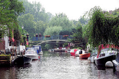 Gracht / Kanal in Friedrichstadt - Sportboote, Motorboote sind am Ufer festgemacht.