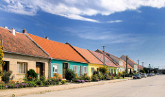 Landestypische Wohnhäuser mit farbiger Fassade und kleinem Vorgarten - Route Brno / Brünn.