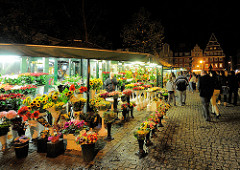 Beleuchteter Blumenstand mit bunten Blumen am Abend auf dem Marktplatz von Wroclaw, Polen.