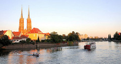 Die Oder in Wroclaw, Breslau am Abend - Motorboot und Raddampfer, Ausflugsschiff auf dem Wasser - die Türme des gotischen Doms / Kathedrale St. Johannes der Täufer werden von der Abendsonne angestrahlt.