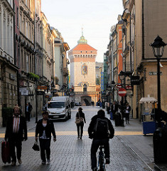 Enge Gasse in Krakau / Kraków - Fussgänger und Radfahrer; im Hintergrund der Turm des Floriantors.