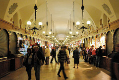 Innenansicht Tuchhallen von Krakau - kleine Verkaufsstände, Souvenirs in den Arkaden - Touristen kaufen Andenken.
