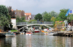 Gracht mit Fussgängerbrücke - Sportboote am Ufer des Kanals.