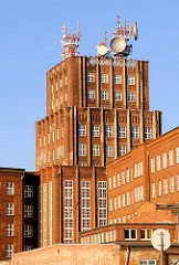 Expressionistisches Postscheckamt Breslau, Wroclaw - Ziegelgebäude, Backsteinfassade - Satellitenschüsseln und Sendeanlagen auf dem Dach.