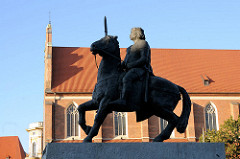 Statue König Boleslaw auf einem Pferd - im Hintergrund das Kirchenschiff der St. Dorothenkirche in Wroclaw, Breslau - Polen.